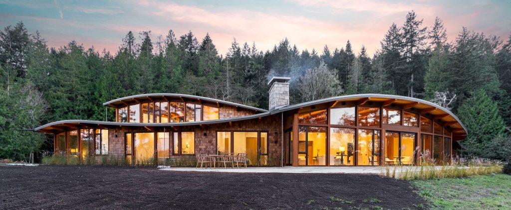 The front facade of a luxury home with a curved rough in Pender Island, BC.