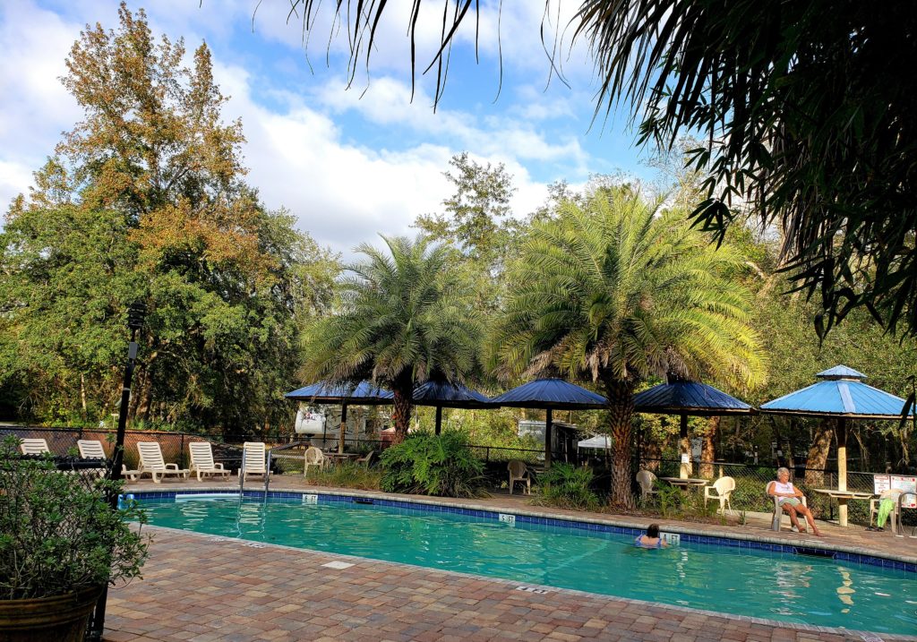 Pool, tables with umbrellas, deck chairs