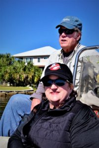 Man driving fishing boat and another female passanger going down canal on fishing adventures