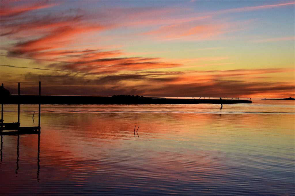 A gorgeous view of the river with pink, orange, and blue sky reflected in the water