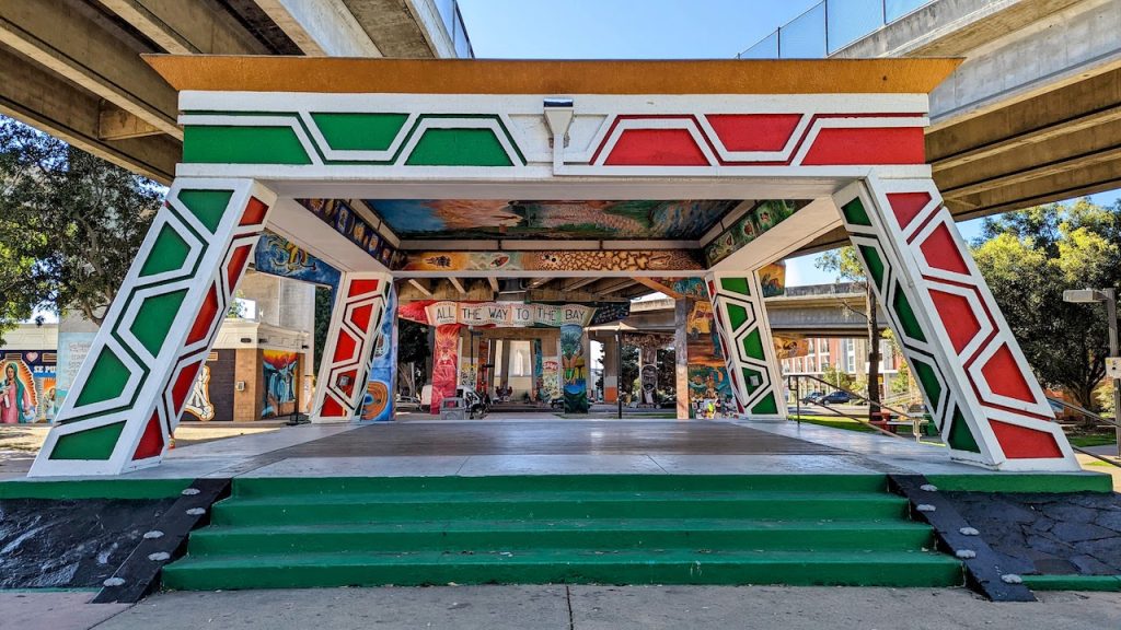 Red and green geometrical-shaped, large-scale paintings on highway underpass. Chicano Park murals, Barrio Logan.