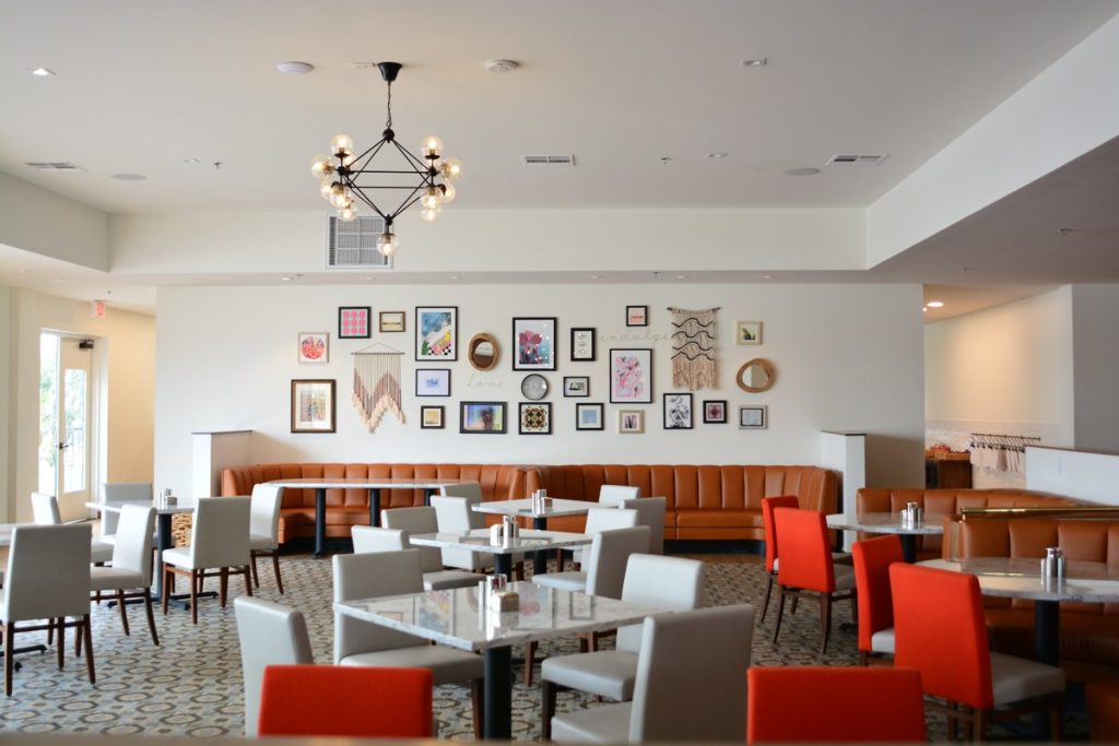 Dining room with red and tan chairs at Hotel Adeline. Credit: Halie Sutton for Experience Scottsdale.