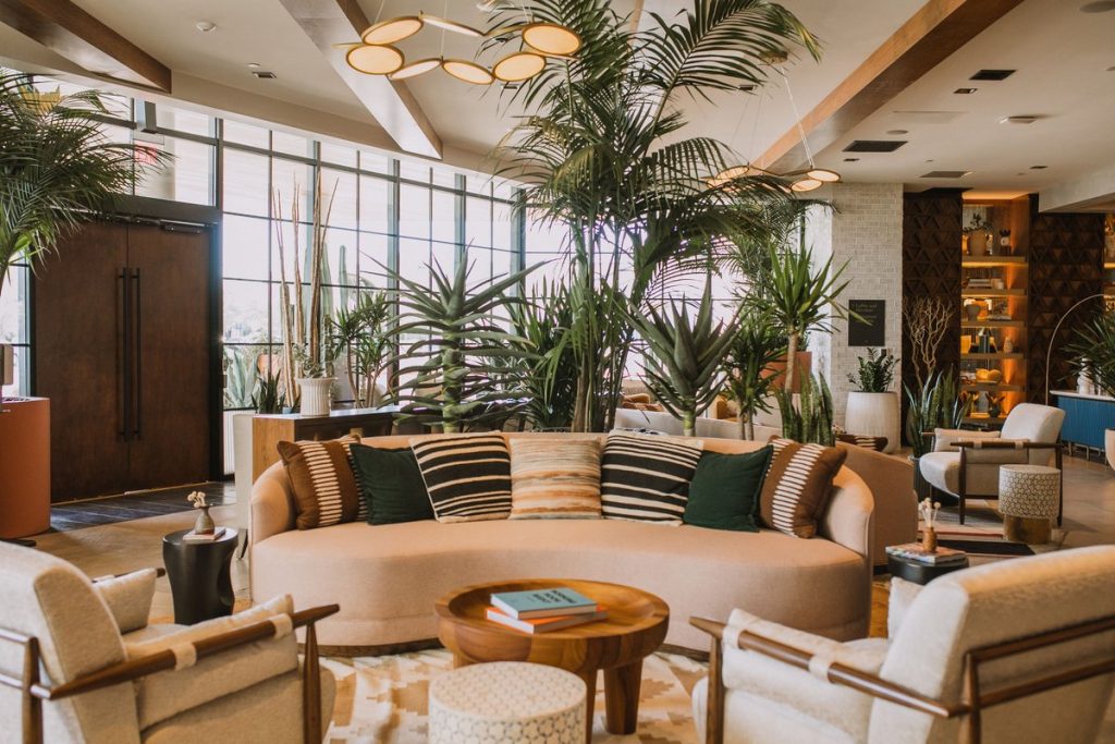 Senna House Hotel Lobby with lots of green plants and tan furniture