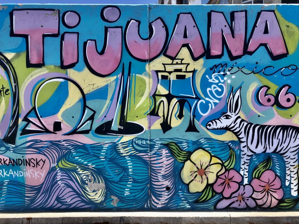 blue and purple wall mural with iconic things that Tijuana is known for, like the CECUT cultural center, the Tijuana zonkey etc