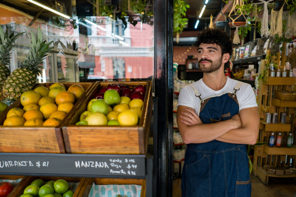 Man working at a local supermarket and waiting for clients