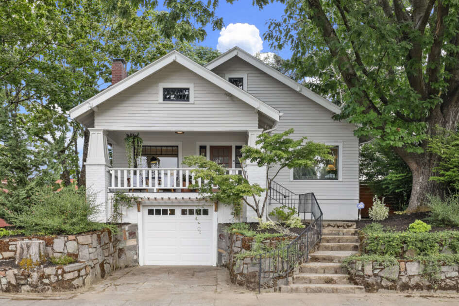 Grey craftsman home with garage and white accents