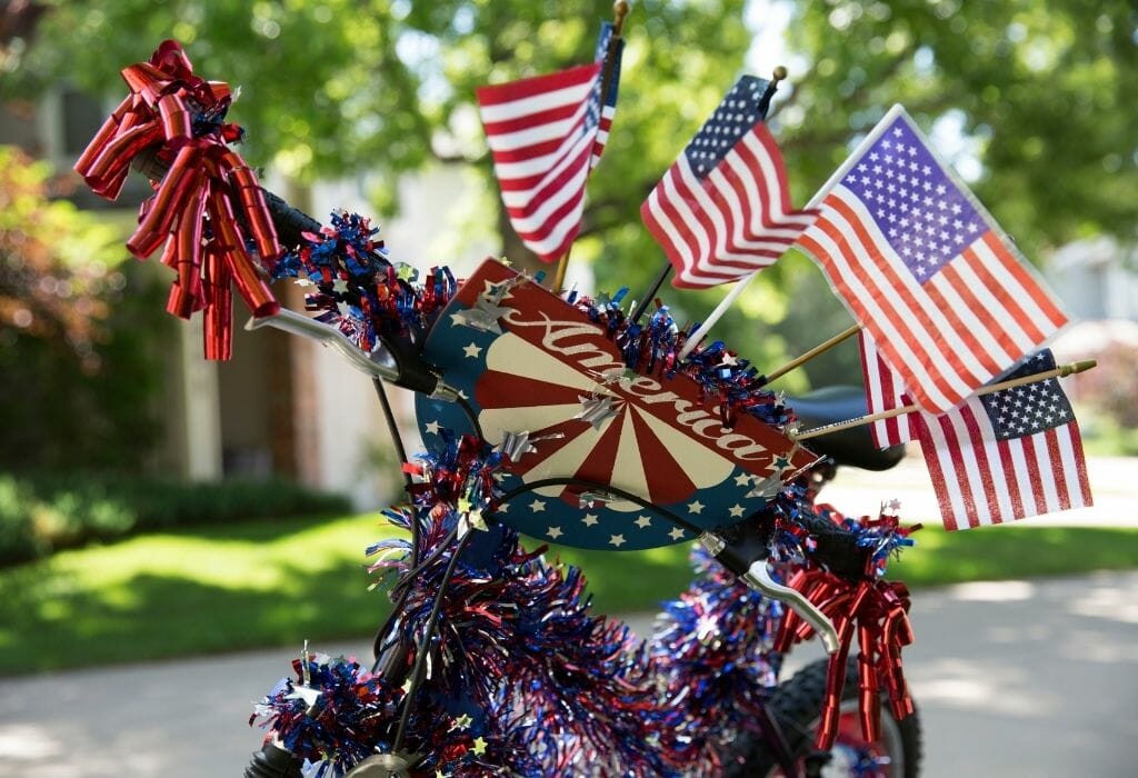 A bicycle decorated with red/white/blue decor and American Flags