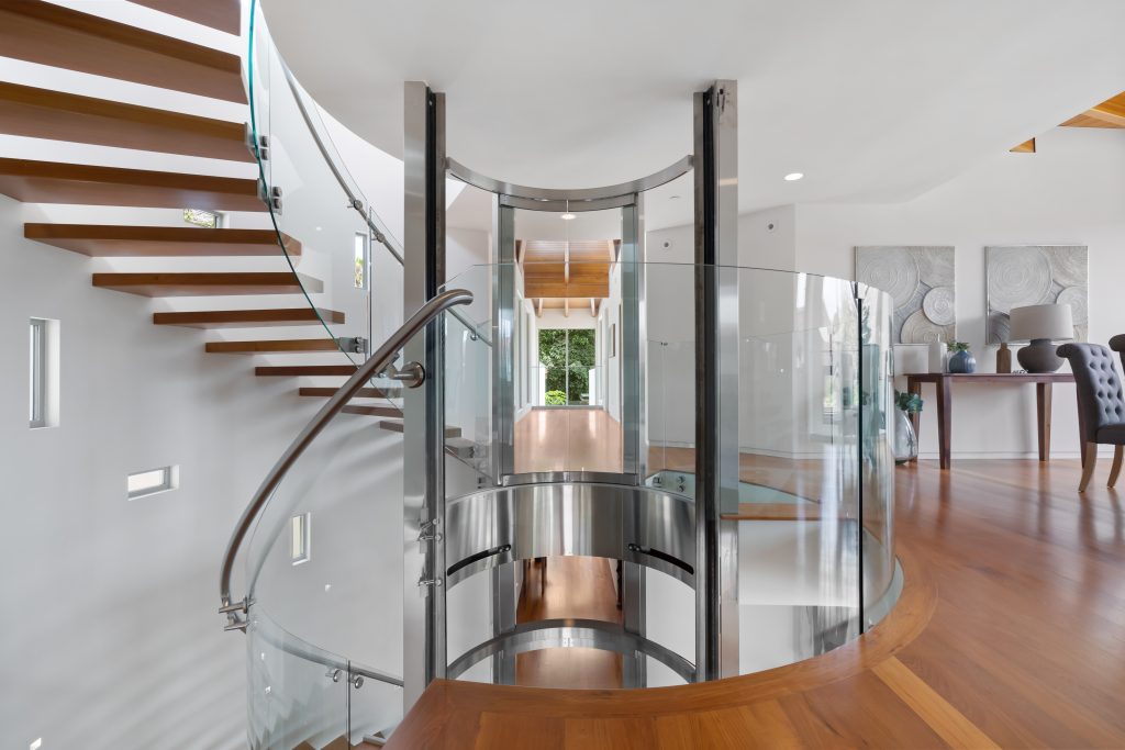 Modern chic elevator encased by floating spiral staircase.