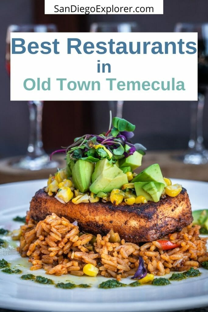 Old Town Temecula restaurants will tantalize your tastebuds and surprise you with innovative dishes & fun dining experiences. Here are the best restaurants in Temecula Old Town that you have to try. 3 glasses of wine in the background, in the foreground, a plate with seasoned rice on the bottom, topped with a fish fillet and vegetables at Old Town Temecula restaurant Bluewater Grill with text overlay: Best Restaurants in Temecula Old Town