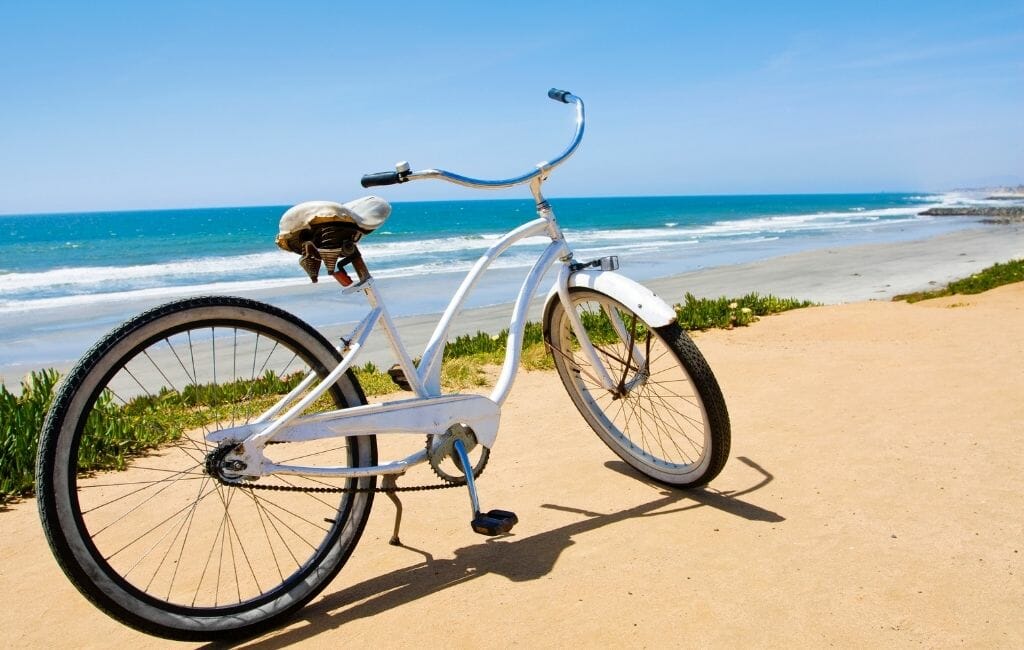 White beach cruiser bike on a sandy path overlooking the ocean