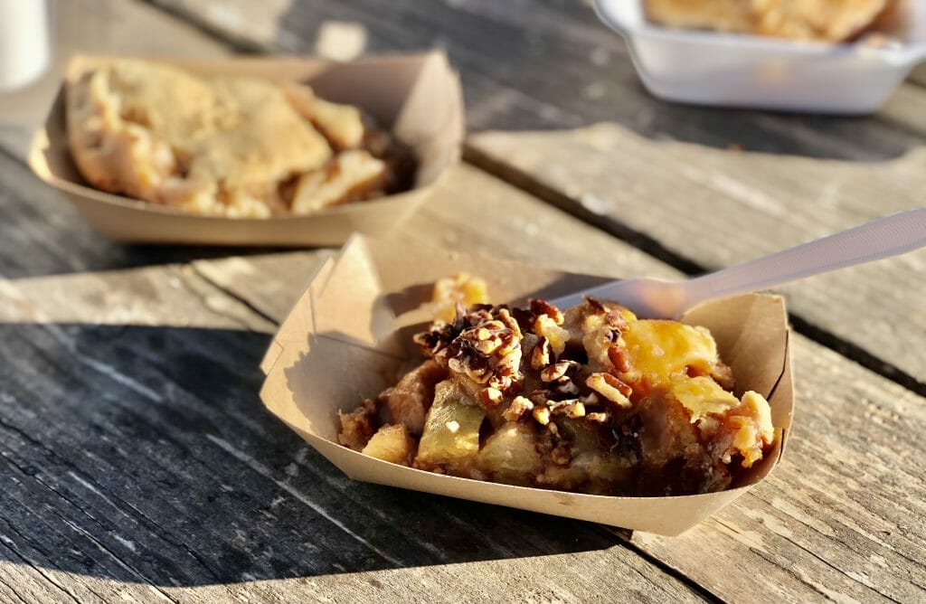 A slice of caramel pecan apple pie in a brown carton bowl - Apple Alley Bakery Julian-Best Julian Apple Pie