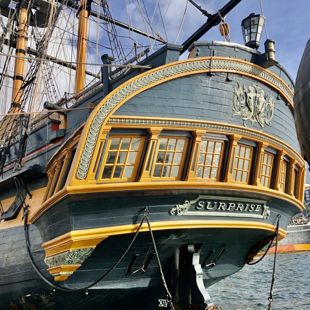 the Stern of the historic replica sail boat with yellow and green wood and intricate design