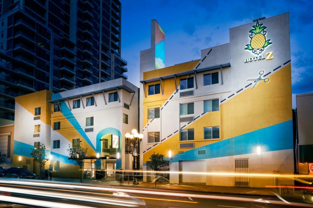 Outside photo of Hotel Z during blue hour. White Facade with yellow and turquoise strips painted on facade 