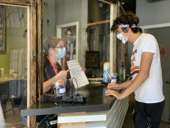 Social Distanced checkin at the HI Hostel San Diego with plexiglass seperator and two people wearing masks