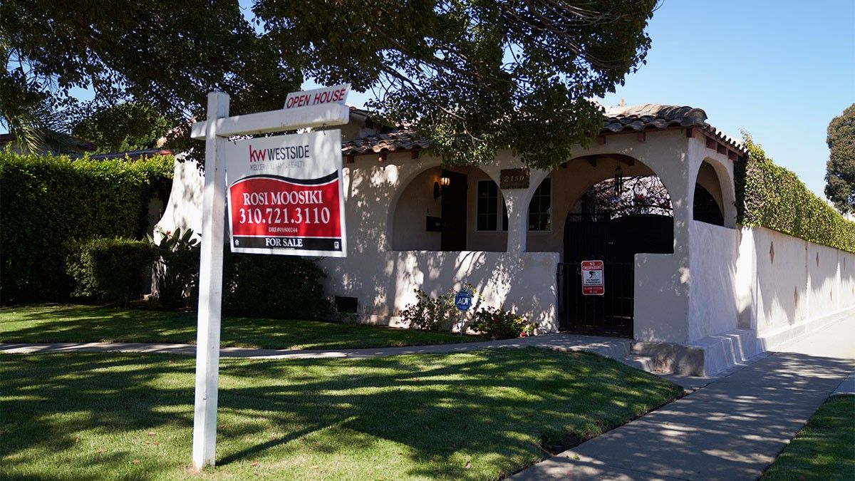 A home for sale with an open house sign in front