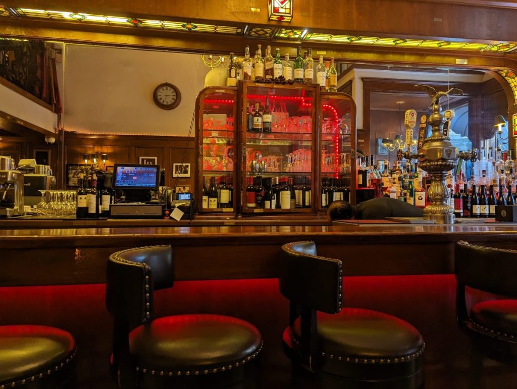 Mahogany bar with mirrored clock at Dobson's Restaurant San Diego