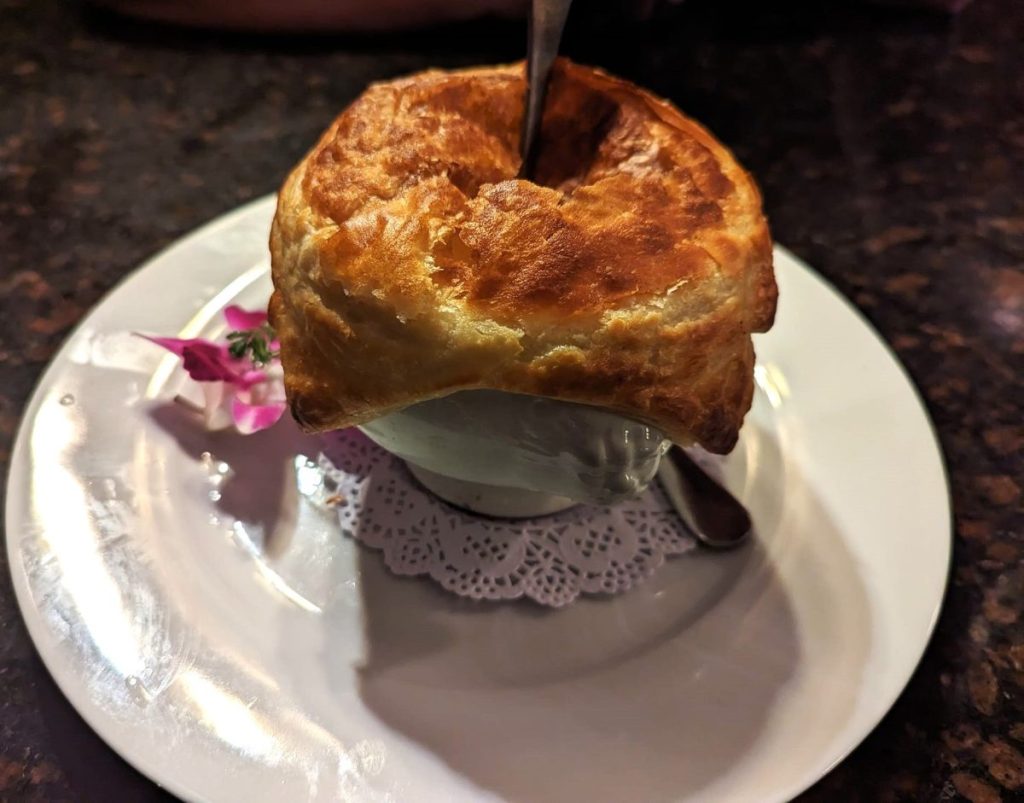 Famous Mussels Bisque at Dobsons with puff pastry top over soup bowl