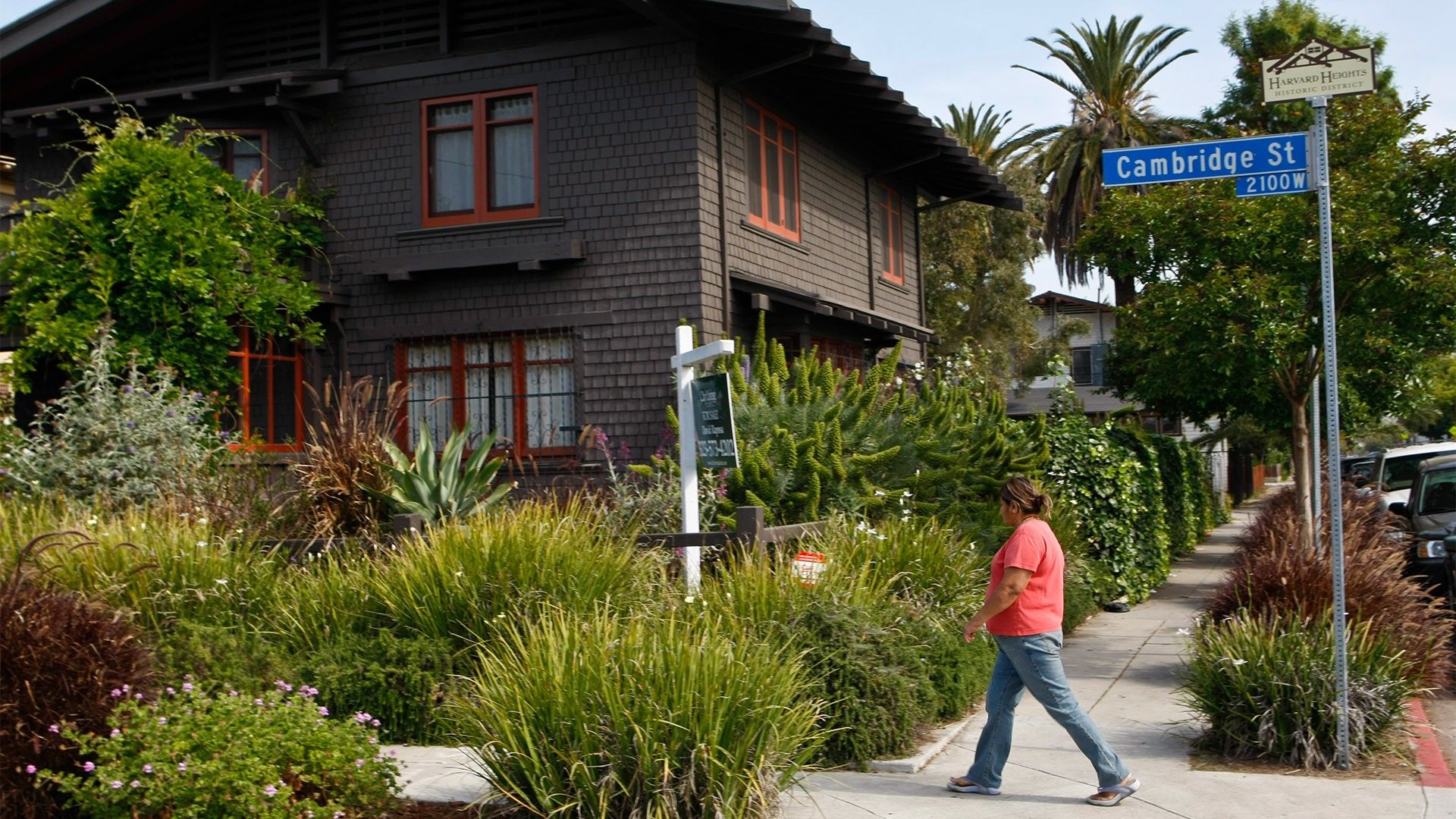 Woman walking past home for sale