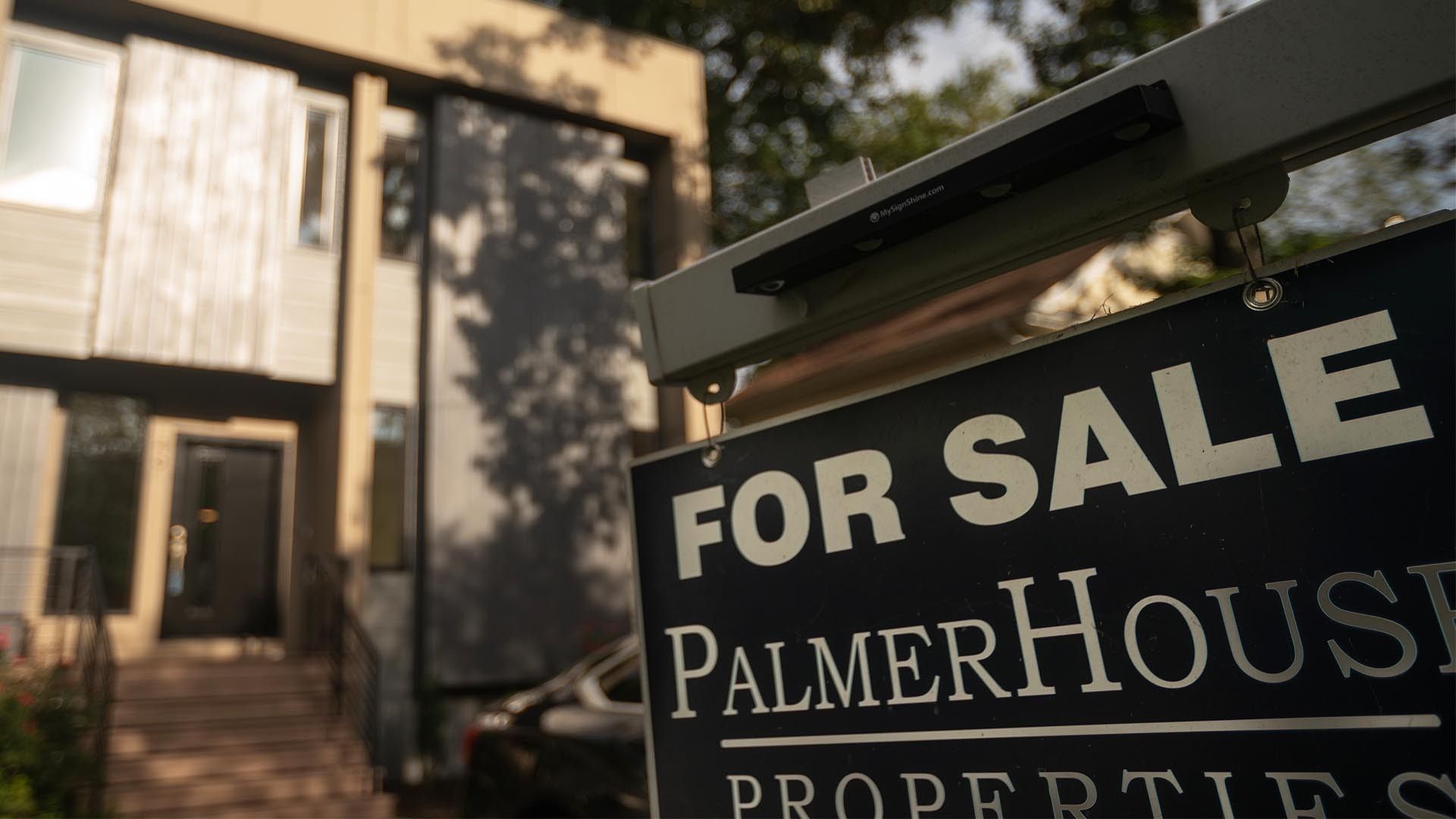 a for sale sign in front of a home