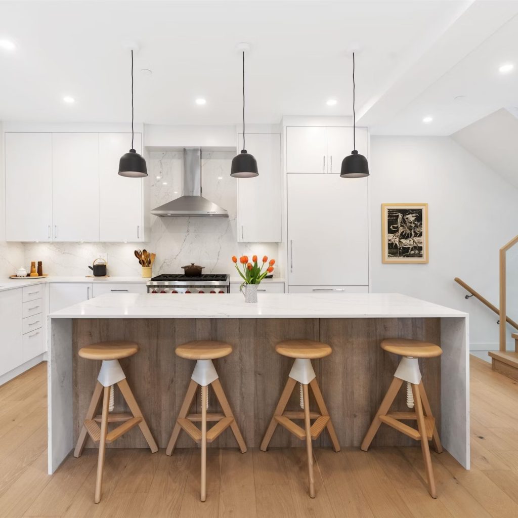 Bright modern kitchen with marble countertops and abstract stools. 