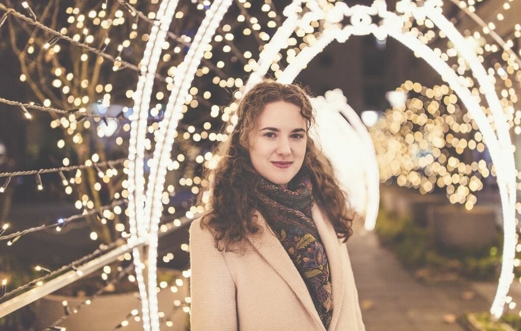 Woman standing in Holiday lights tunnel