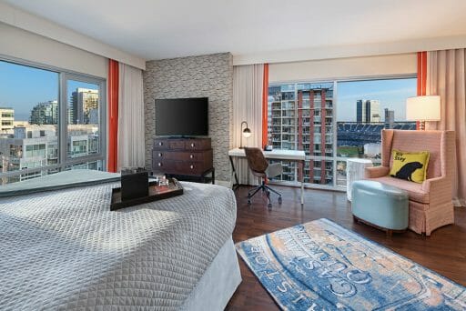 Hotel Room at Hotel Indigo with bed, recliner and two large windows looking out at Petco Park