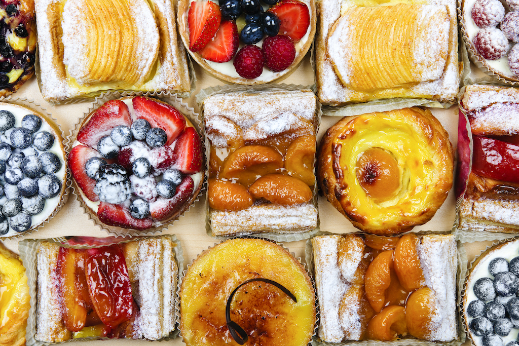 Background of assorted fresh sweet tarts and pastries from above