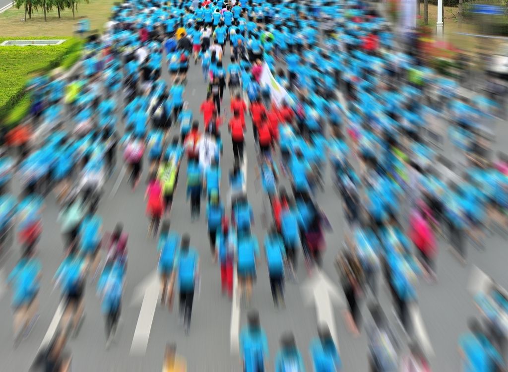 long exposure of running race with blurry runners on a street