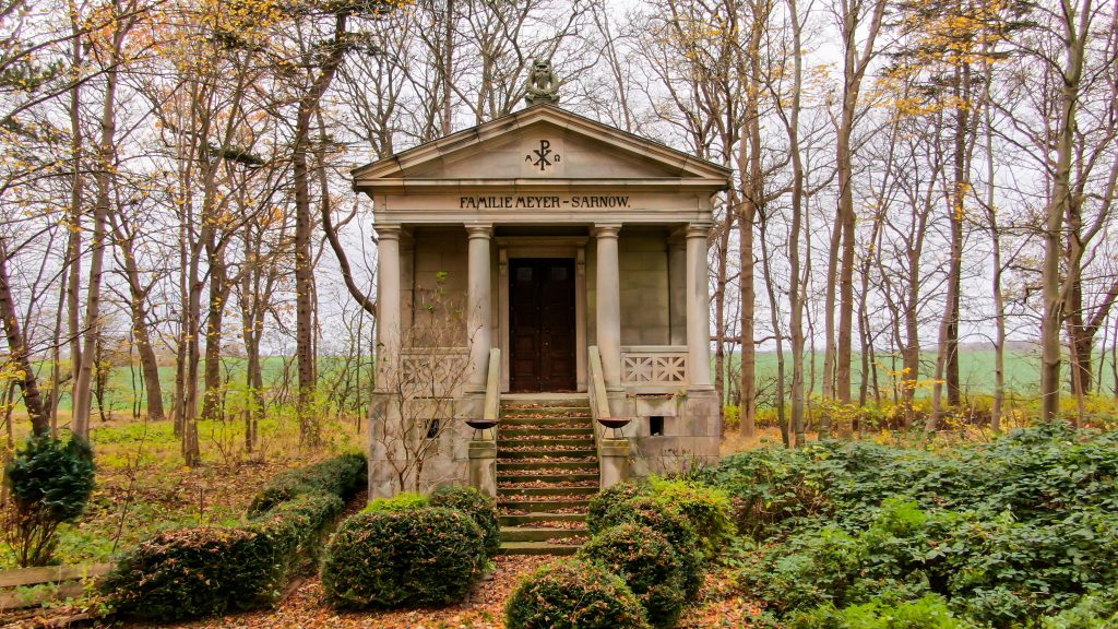 Neoclassical mausoleum surrounded by trees in the fall time.