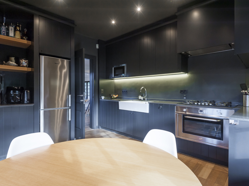 Kitchen with dark appliances and low lighting.