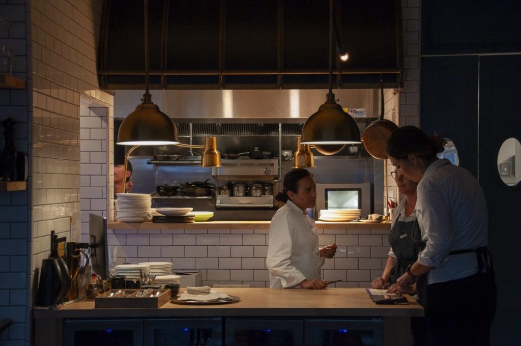 Chef Itze talking to staff in front of Kitchen