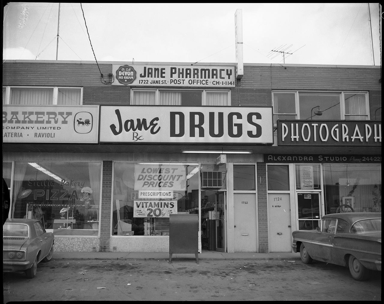 By 1961, most of 1692 – 1732 Jane St. in Toronto's Weston neighbourhood had been built, with businesses including a dry cleaner, drug store, and Alexandra [photography] Studio.