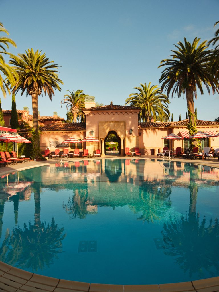 Hotel pool at Fairmont Grand Del Mar with spanish architecture building and palm trees