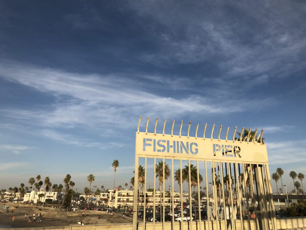 gate at Ocean beach pier with beach and blue sky in the background