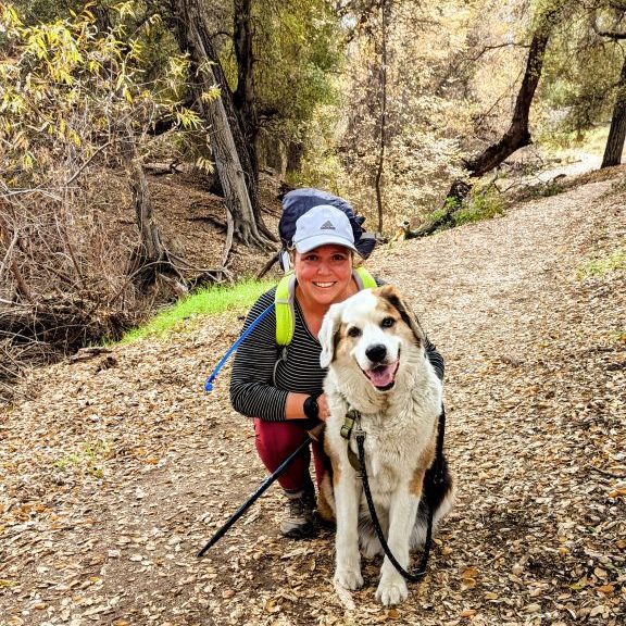 Female hiker Maria Haase with her dog Robby hiking in San Diego