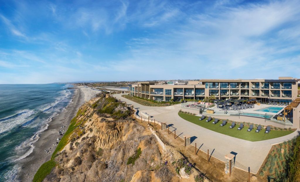 Modern, luxury hotel atop beach bluff overlooking Pacific Ocean and beaches on sunny day. Alila Marea Hotel, San Diego boutique Hotels