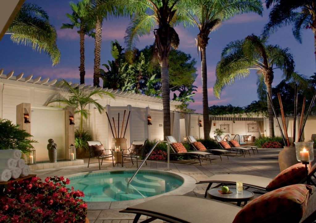 Nighttime shot of hot tub and pool area with lounge chairs and palm trees. Loews Coronado Bay Resort.