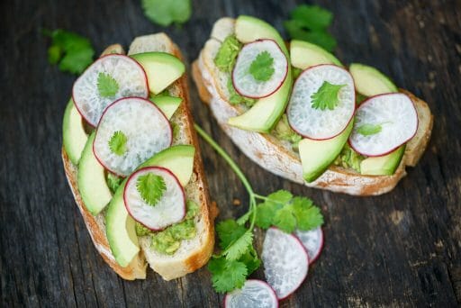 Avocado and Radish toast on wood background