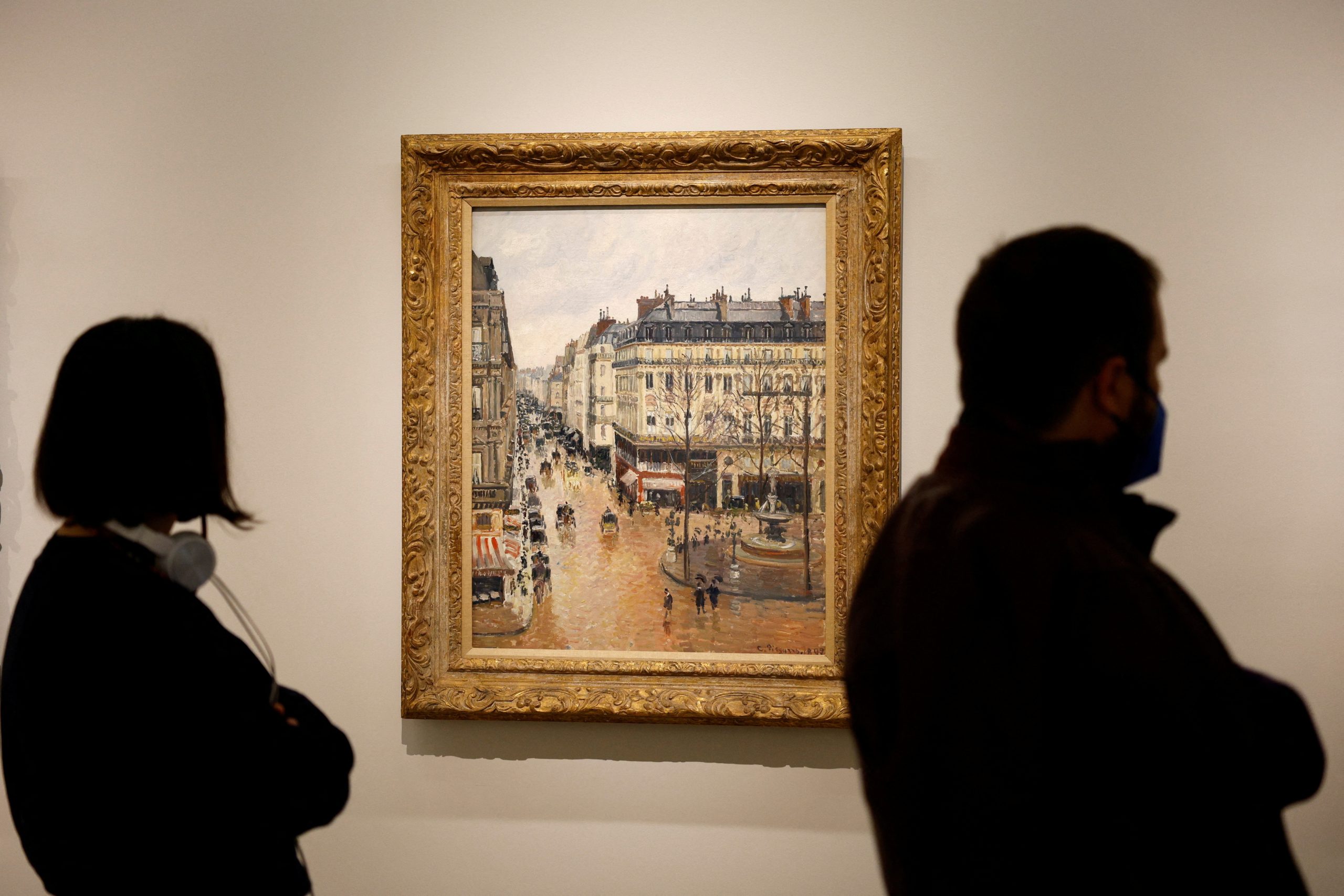 FILE PHOTO: Visitors stand by Camille Pissarro's "Rue Saint-Honore in the Afternoon. Effect of Rain, 1897" at Thyssen-Bornemisza museum in Madrid, Spain, April 22, 2022. REUTERS/Susana Vera/File Photo