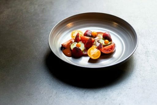 A gray saucer with colorful fruits lovingly arranged