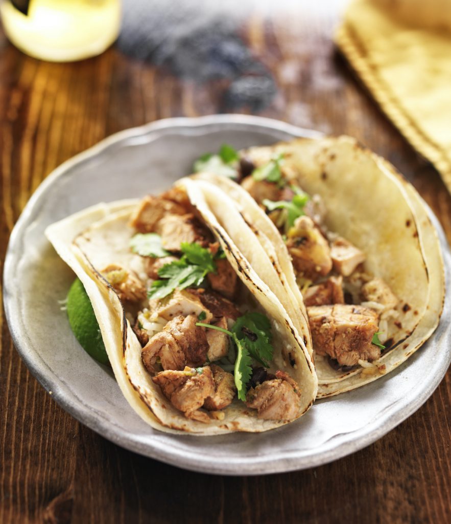 Two chicken tacos with cilantro in corn tortillas