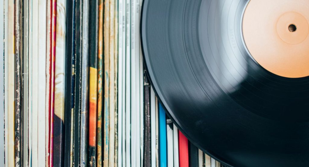 Close up of two vinyls laying on stack of vinyl covers. Vinyl Record Stores San Diego