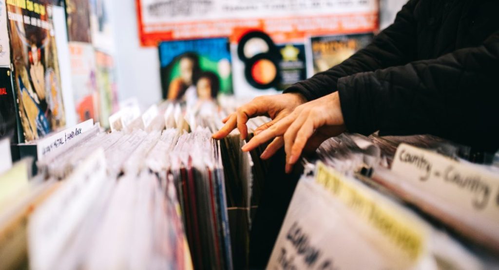 Person looking through vinyls at music record store. Vinyl Record Stores San Diego.