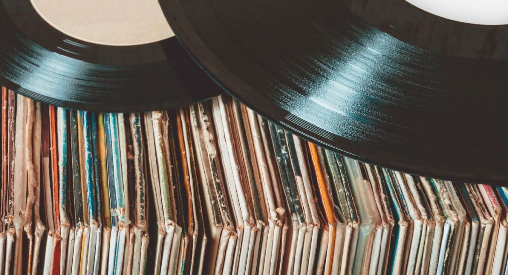 Close up of two vinyls laying on stack of vinyl covers. Vinyl Record Stores San Diego