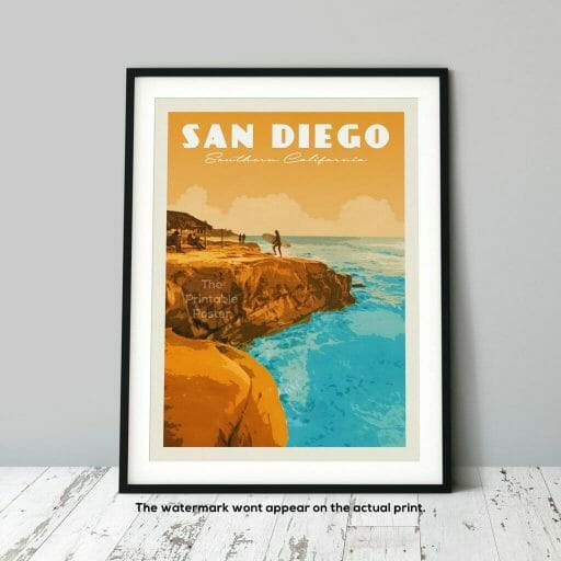 vintage print of San Diego coast line picturing orange cliffs and turquoise ocean, leaning on a grey wall