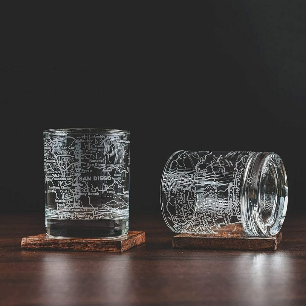 2 Whisky glasses on a table with San Diego map etched into glass in front of a black background 