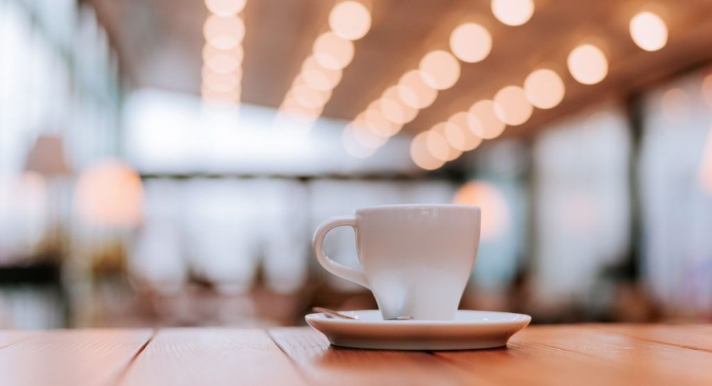 Coffee mug on table in brightly lit coffee shop. San Diego Coffee Shops.