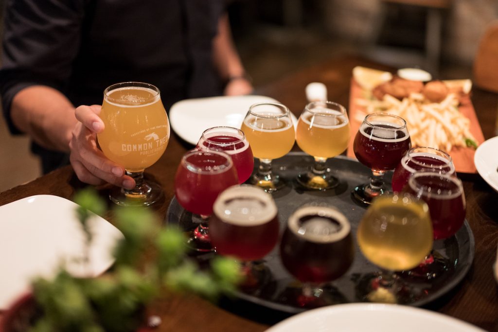 Server serving beer from tray full of craft beer in a restaurant. Common Theory Public House, san diego dog friendly restaurants