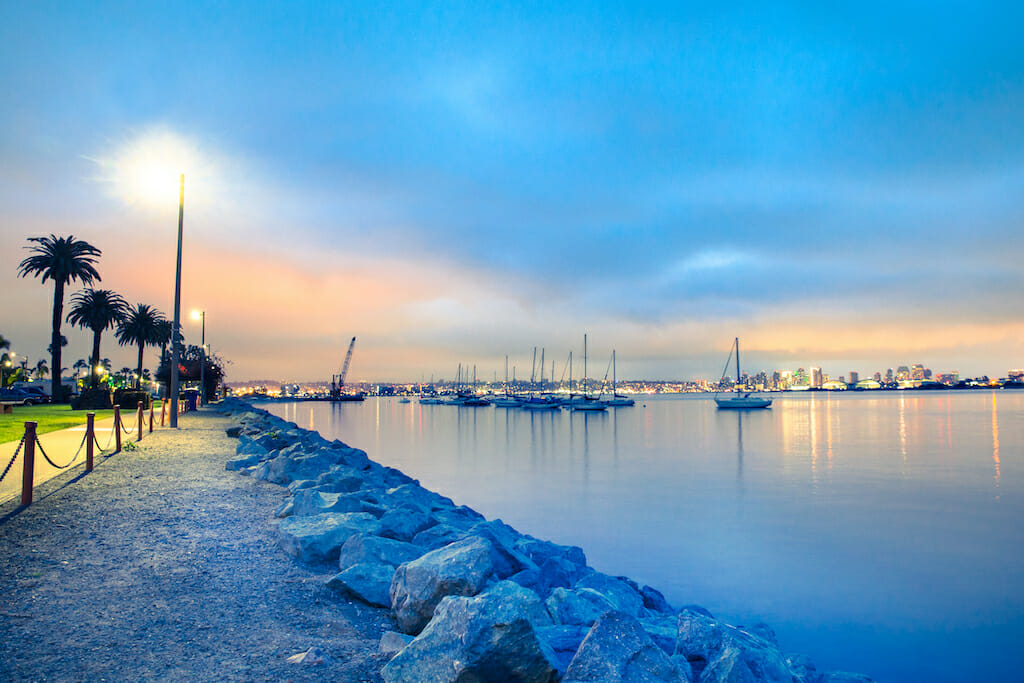 View of San Diego California at sunset with boats and buildings seen across the water