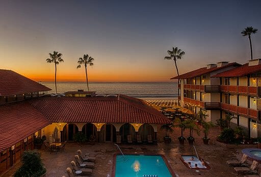 The sun sets over the water yet still shines over the pool and red bricks